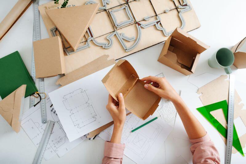 A person assembles a carton created as part of a brand’s packaging design and printing services