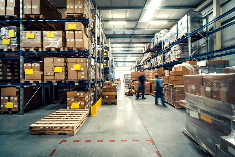 A warehouse with people and merchandise moving in various directions