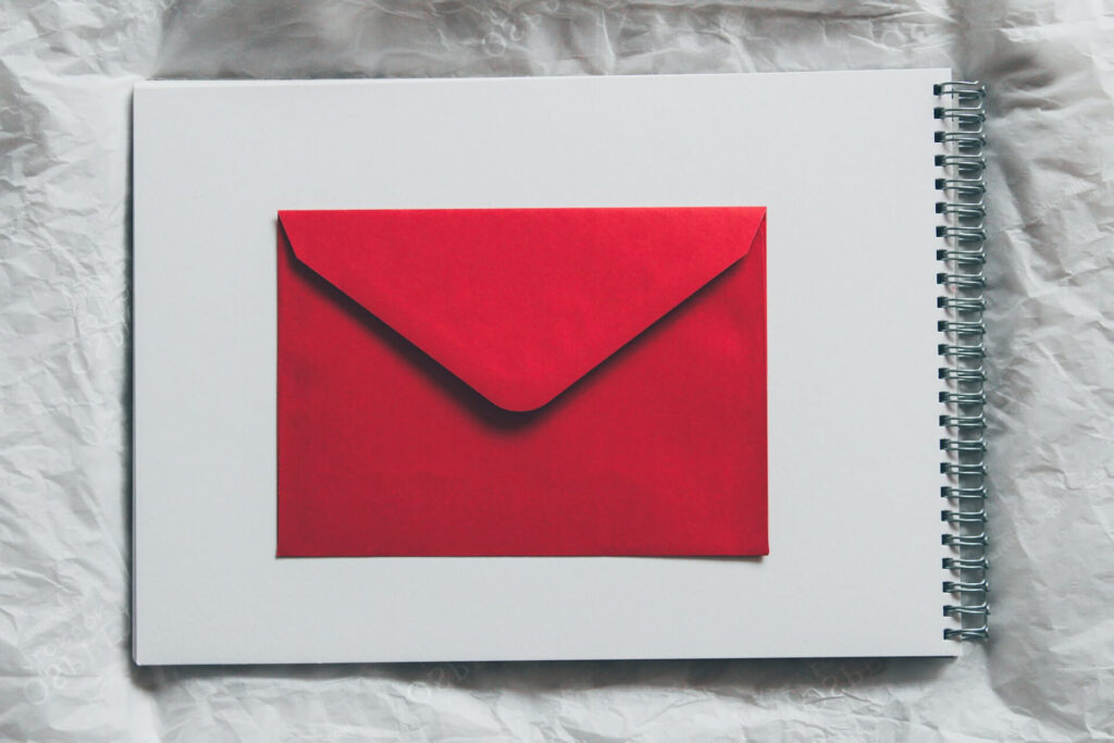 A red envelope on top of a notebook