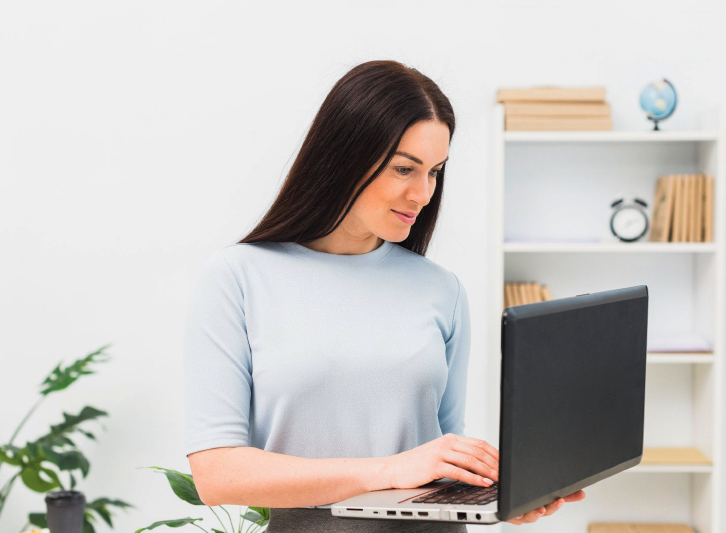 Woman smiling holding laptop. 